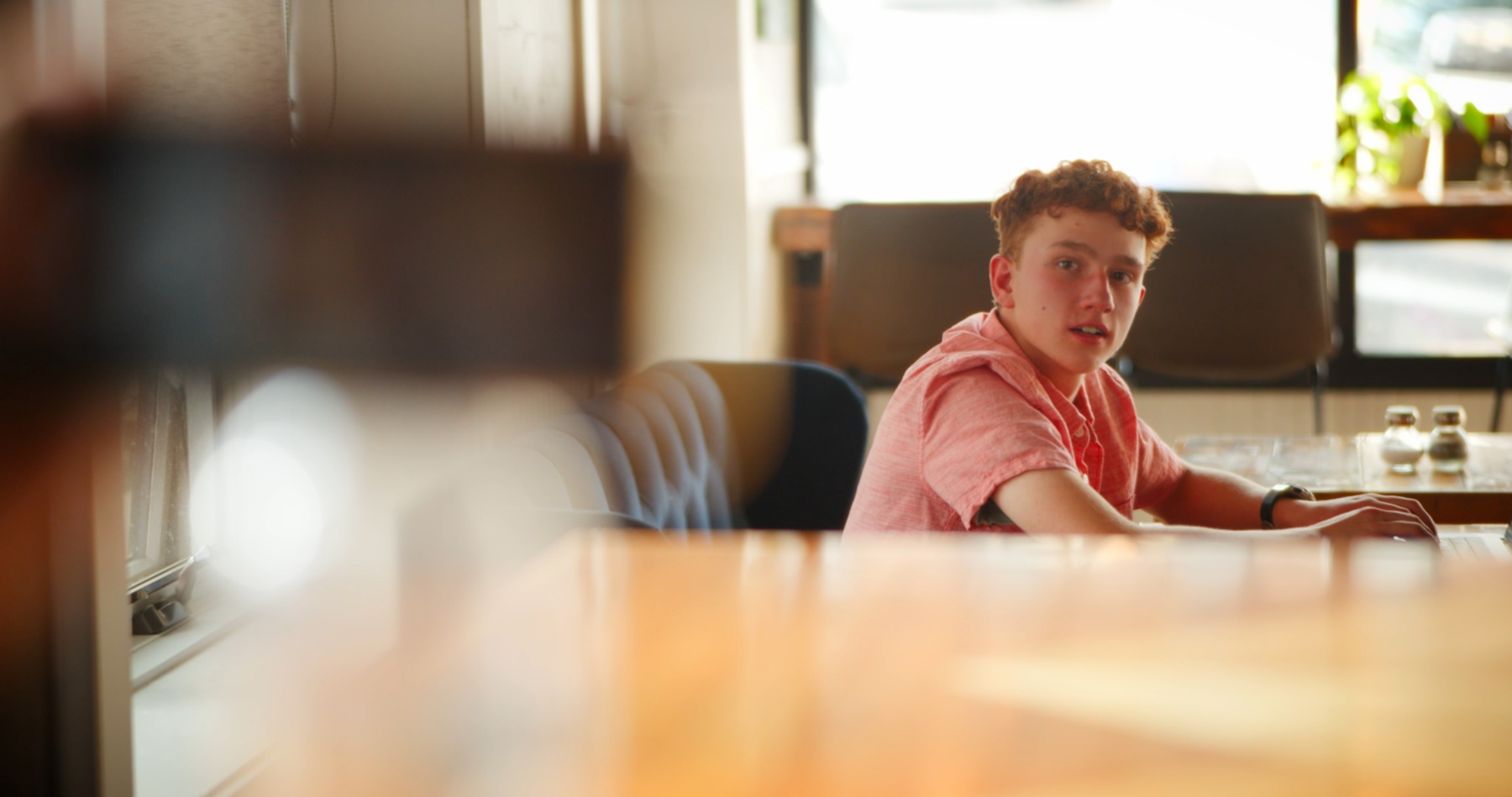 Ryan glances over from a diner booth.