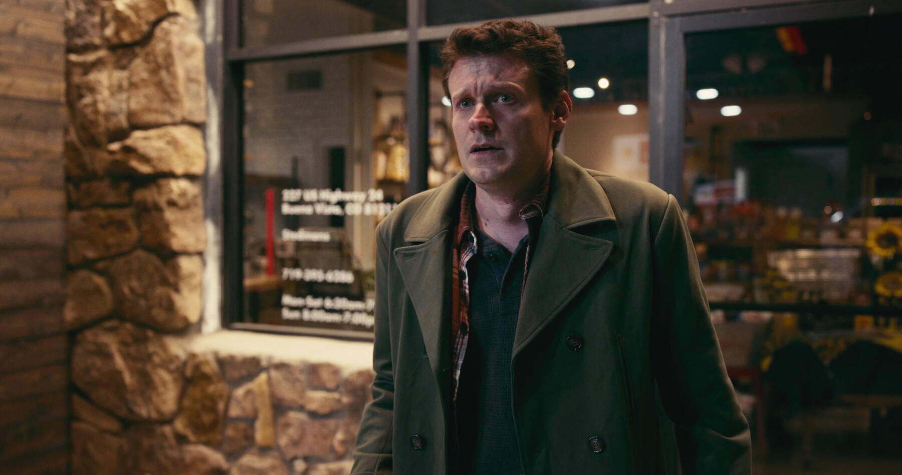 Milo stands outside the store, shaken, just after the robbery.
